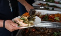 a hand holding a plate with food in bathurst